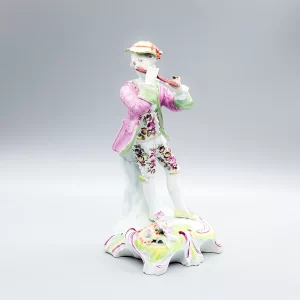 Derby figure of a flautist, supported by a rocky stump, circa 1756-58